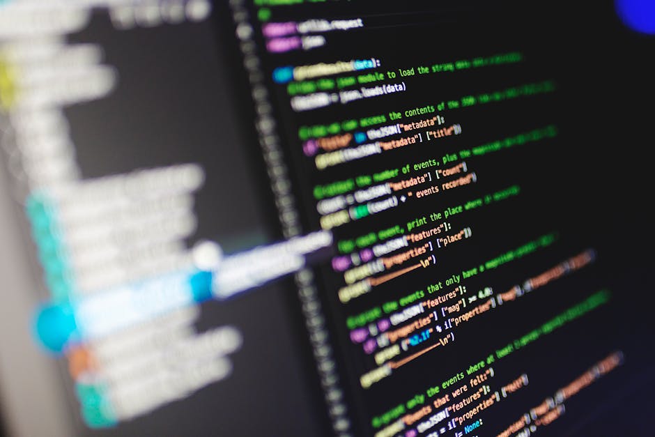 A close-up view of a computer screen displaying lines of colorful code with various syntax elements such as keywords, variables, and comments in different colors including green, purple, orange, and w